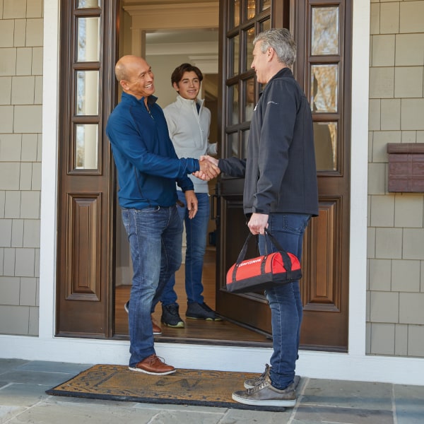 Ace Hardware Home Services technician greeting homeowners Ace Hardware Home Services technician greeting homeowners