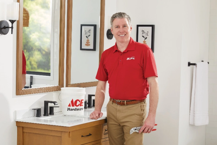 Ace Hardware Home Services plumber next to a bathroom sink